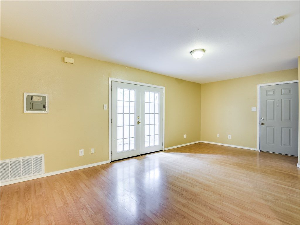 Bright empty room with hardwood floors and French doors.